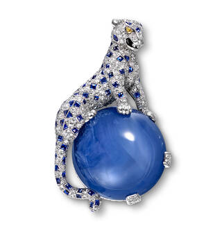 Brooch featuring jewel-encrusted panther sat on a large blue circular stone
