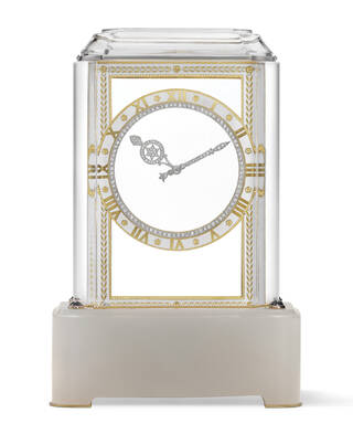 Numberless, circular, see-through clock face on clear case with milky-grey base and gold feet